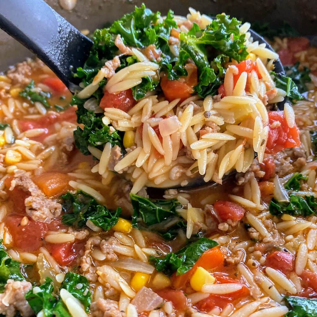 a scoop of sausage orzo soup