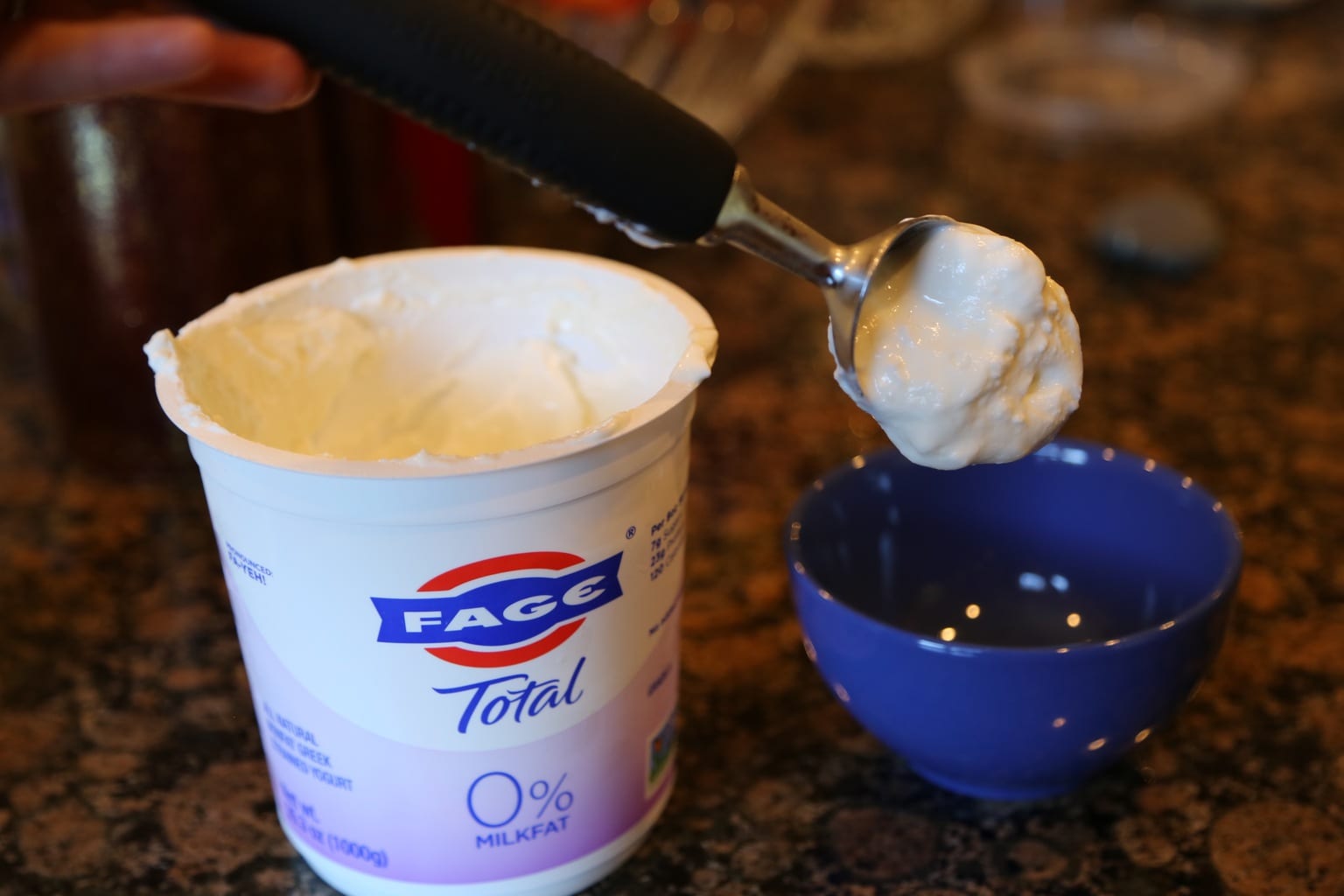 Child scooping yogurt into bowl
