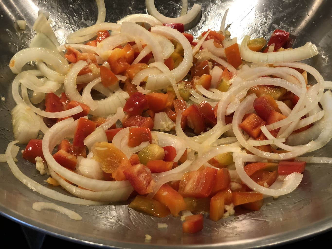 onions and peppers cooking in pan