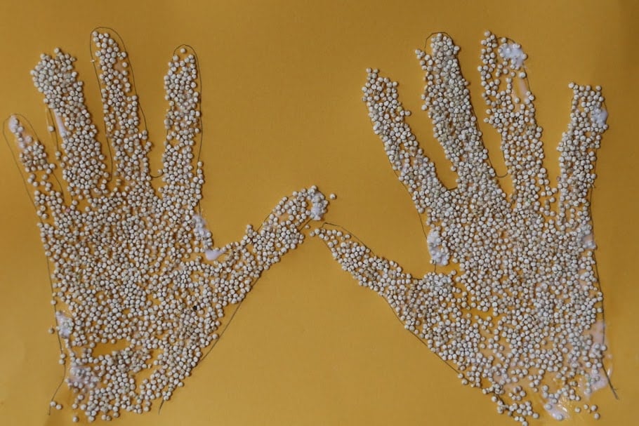 traced hands with glued quinoa