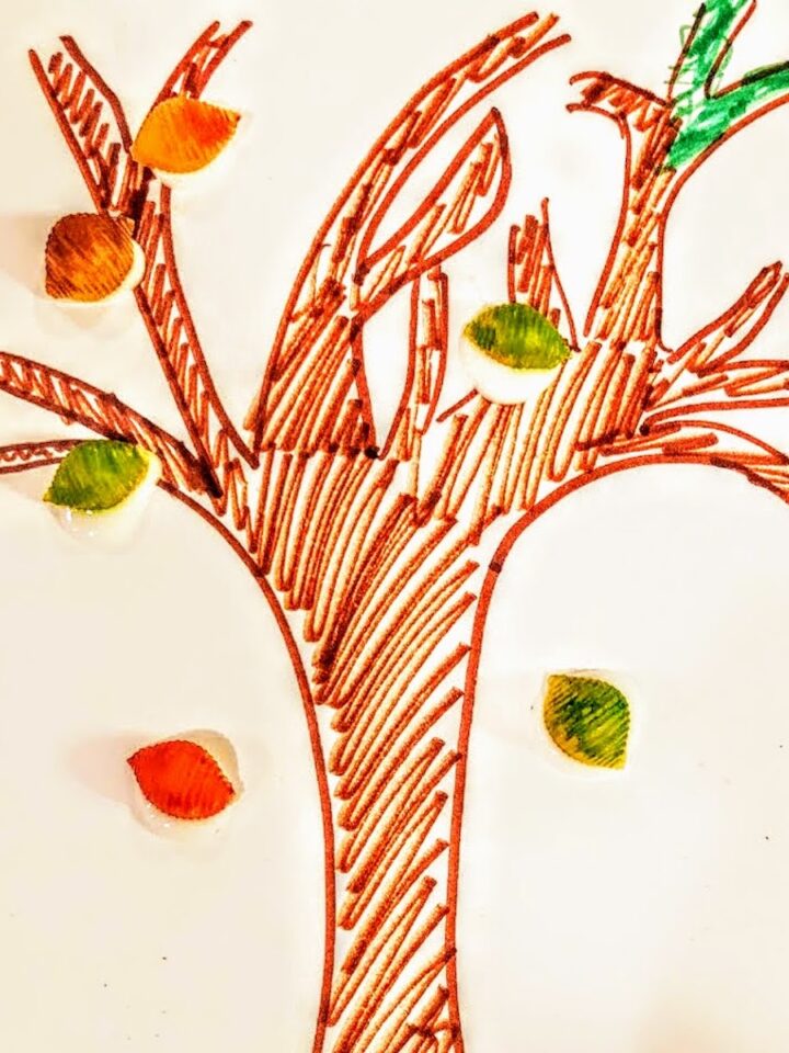 tree drawn on paper with dyed pasta shells as leaves