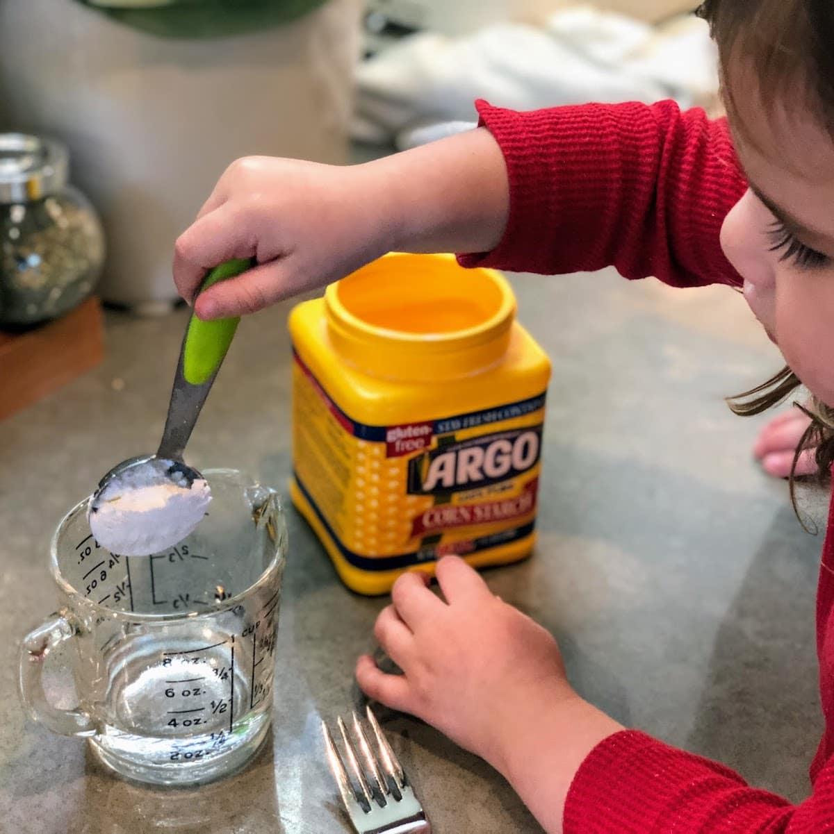 Child scooping up cornstarch