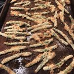 green bean fries in baking sheet, baked and browned