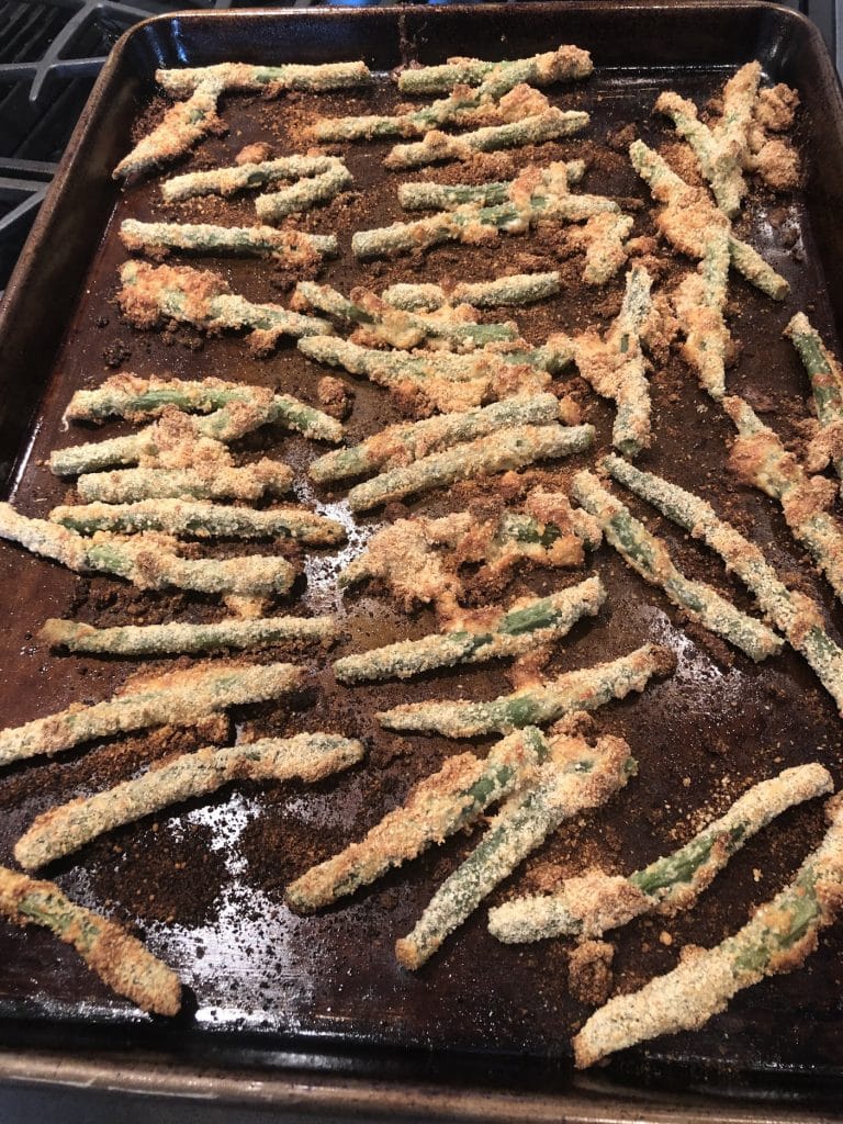 green bean fries in baking sheet, baked and browned