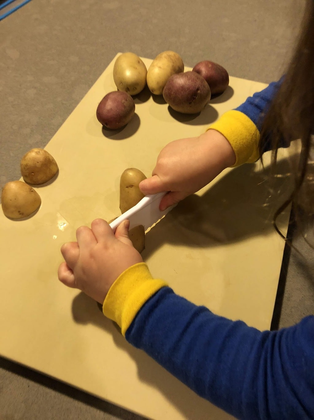 Child slicing potatoes
