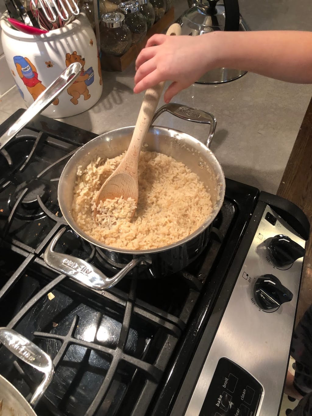 child stirring brown rice