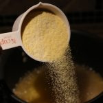 Chid pouring cornmeal into pot