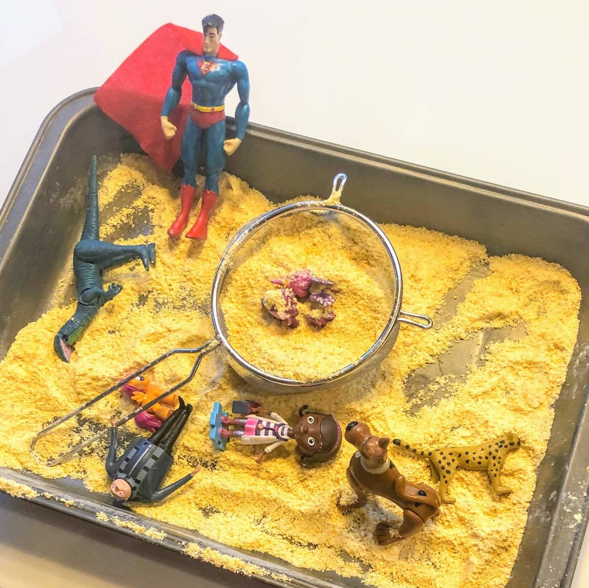 kitchen pan filled with cornmeal and toys
