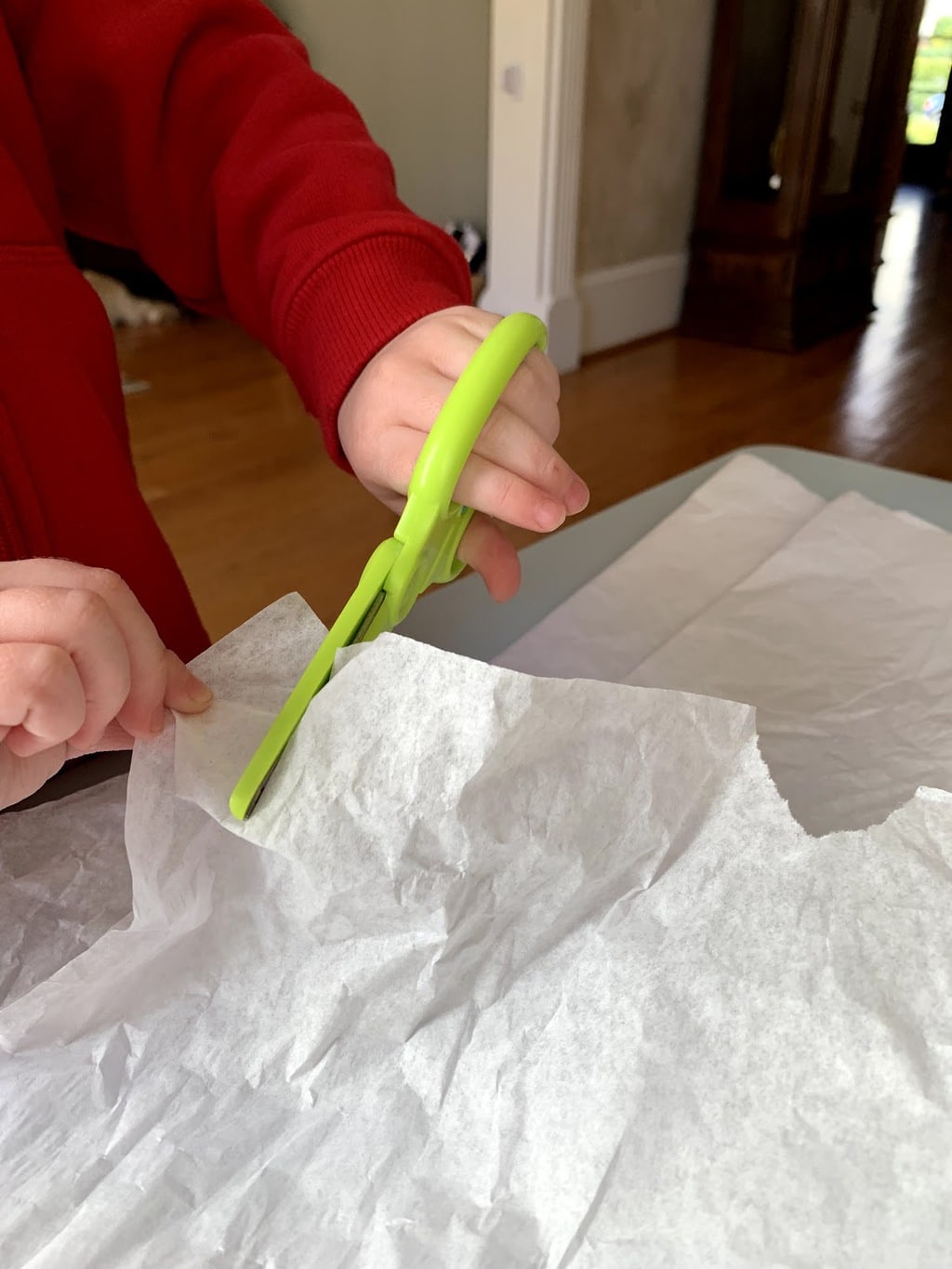 Child cutting white tissue paper