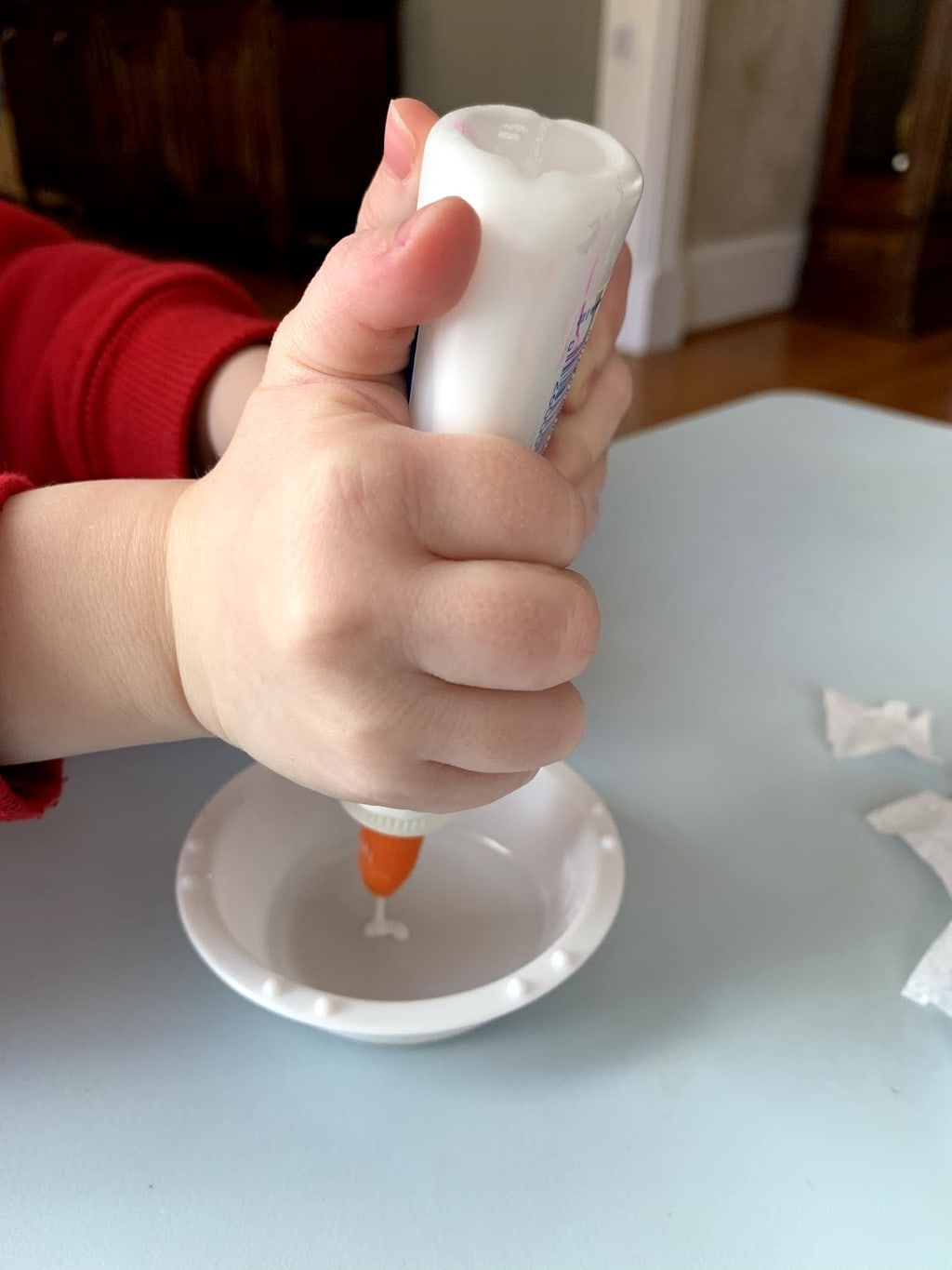 Child putting glue into a bowl