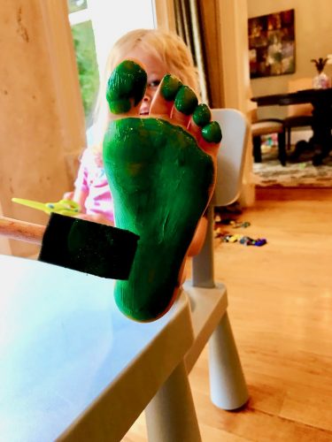 Child painting bottom foot for craft