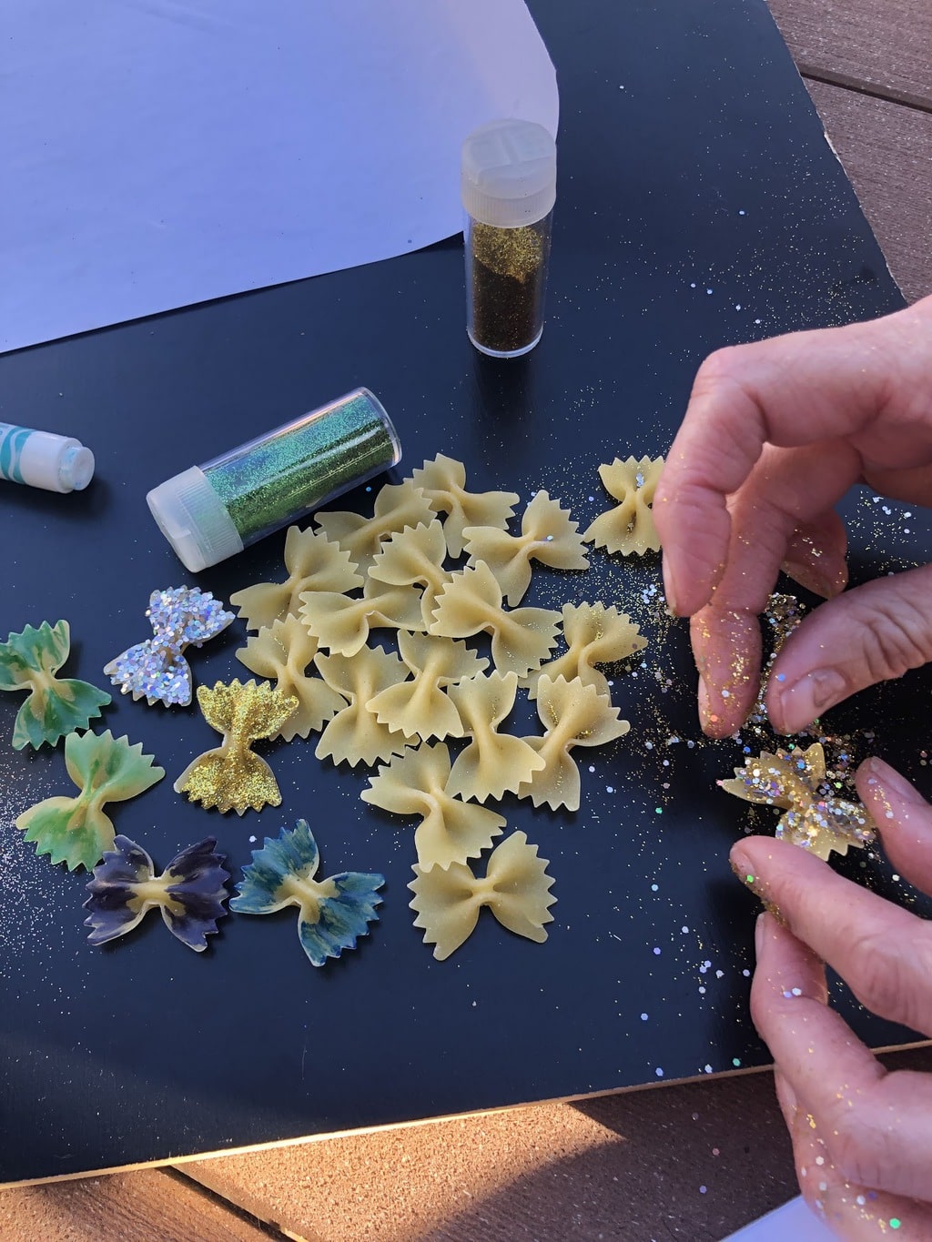 Sprinkling glitter on pasta butterflies