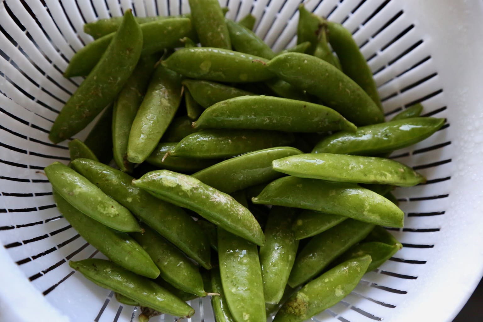 sugar snap peas in a strainer