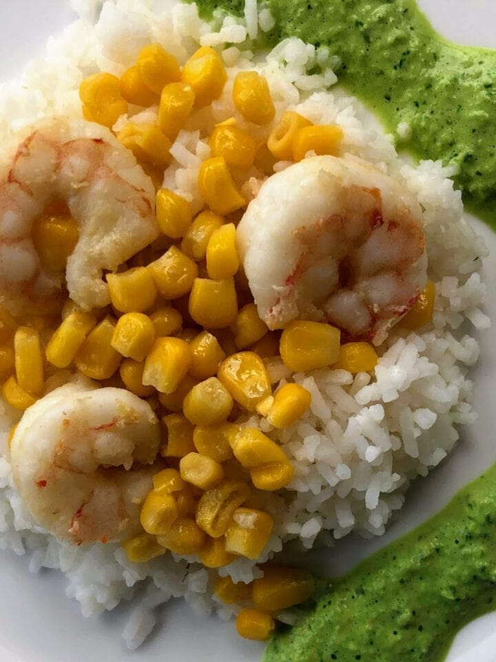 shrimp with rice corn and green sauce on white plate