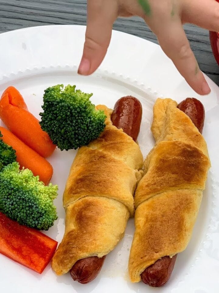 crescent roll hot dogs with veggies on plate