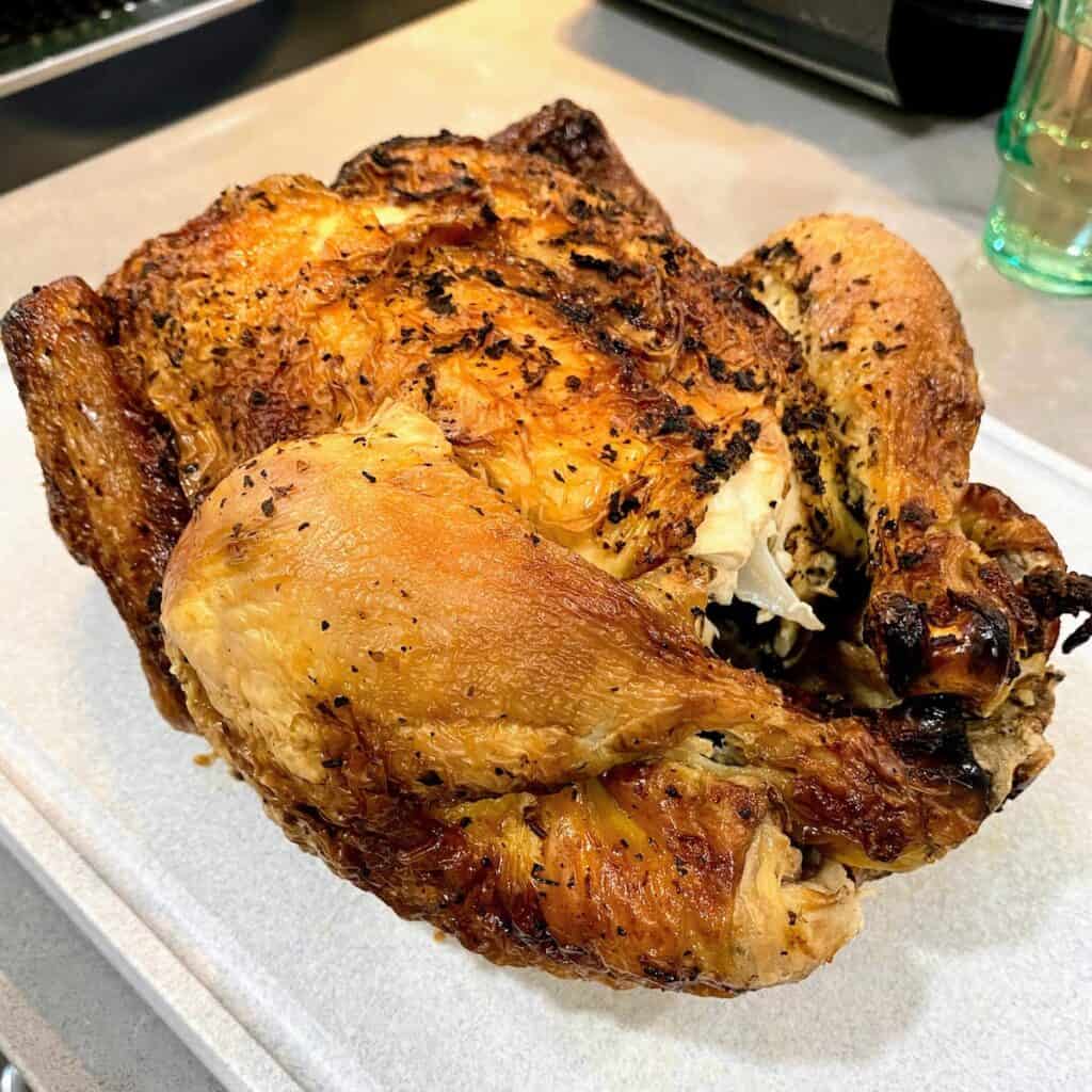 full roasted chicken on cutting board out of packaging
