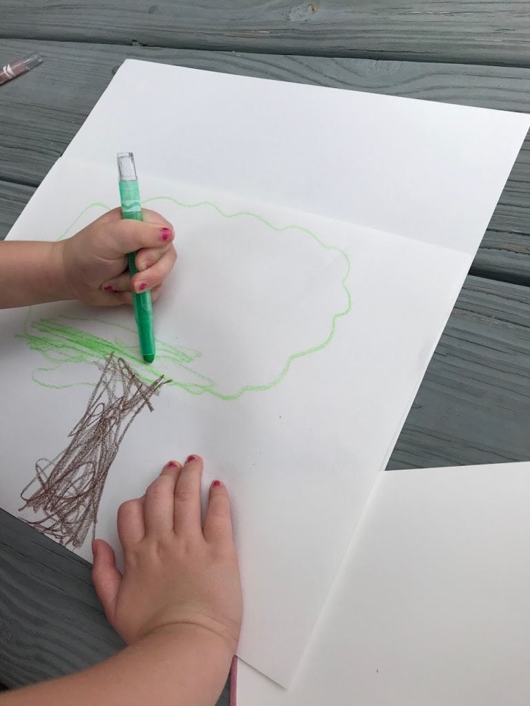 child coloring in tree
