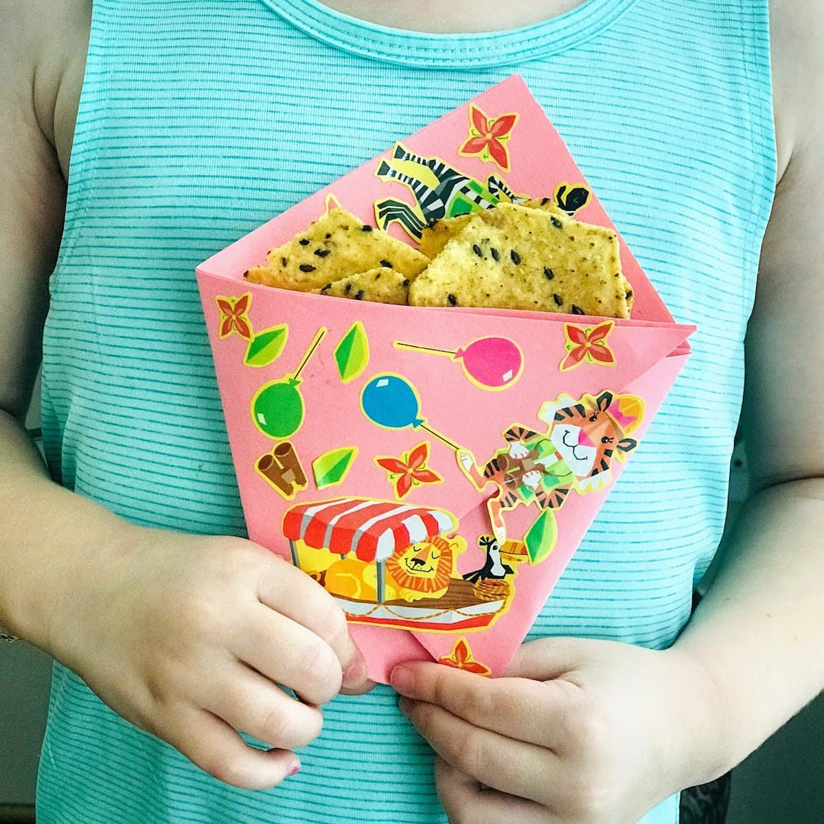 child holding origami paper bag with chips