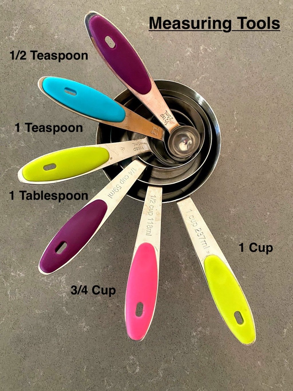 measuring cups and spoons on grey counter