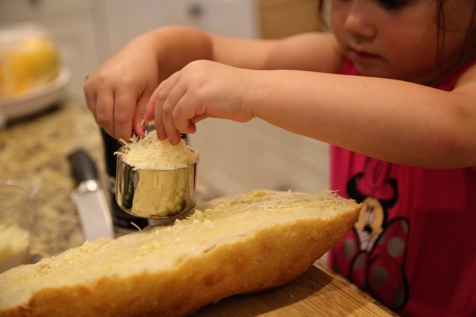child adding cheese to bread