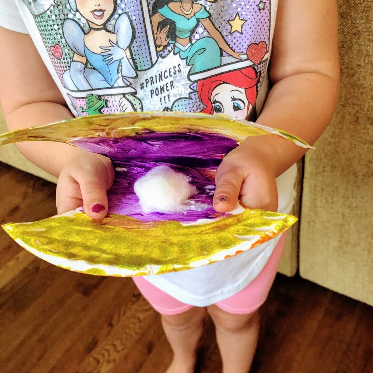child holding scallop shell craft