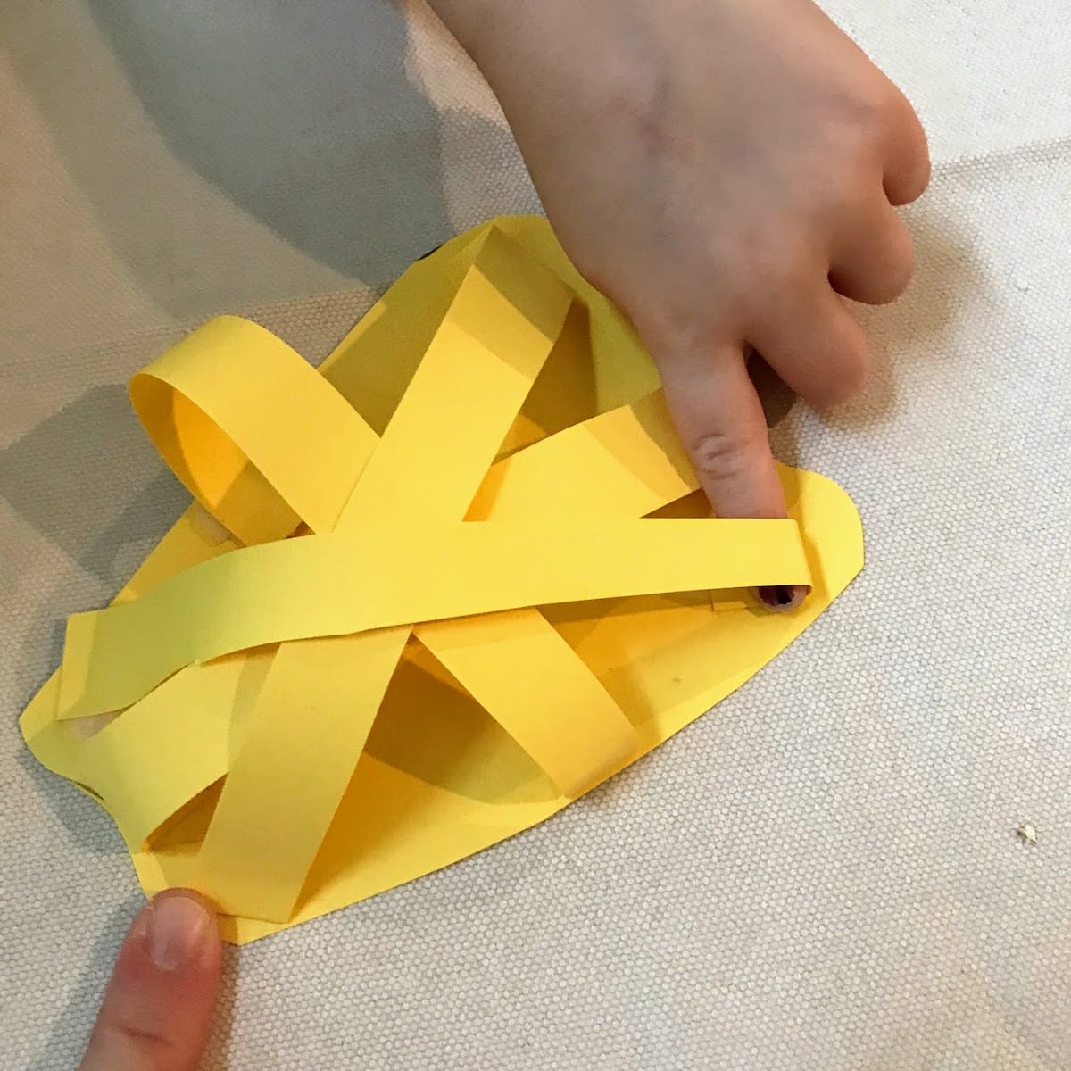 Placing third yellow strip on 3d paper pepper