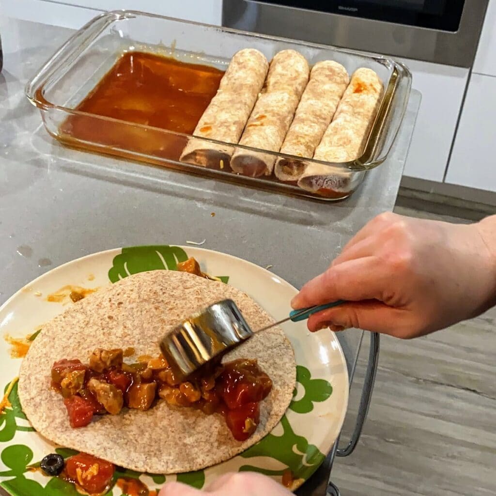 person assembling enchiladas