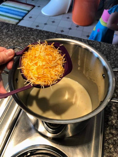 adding cheese to pot