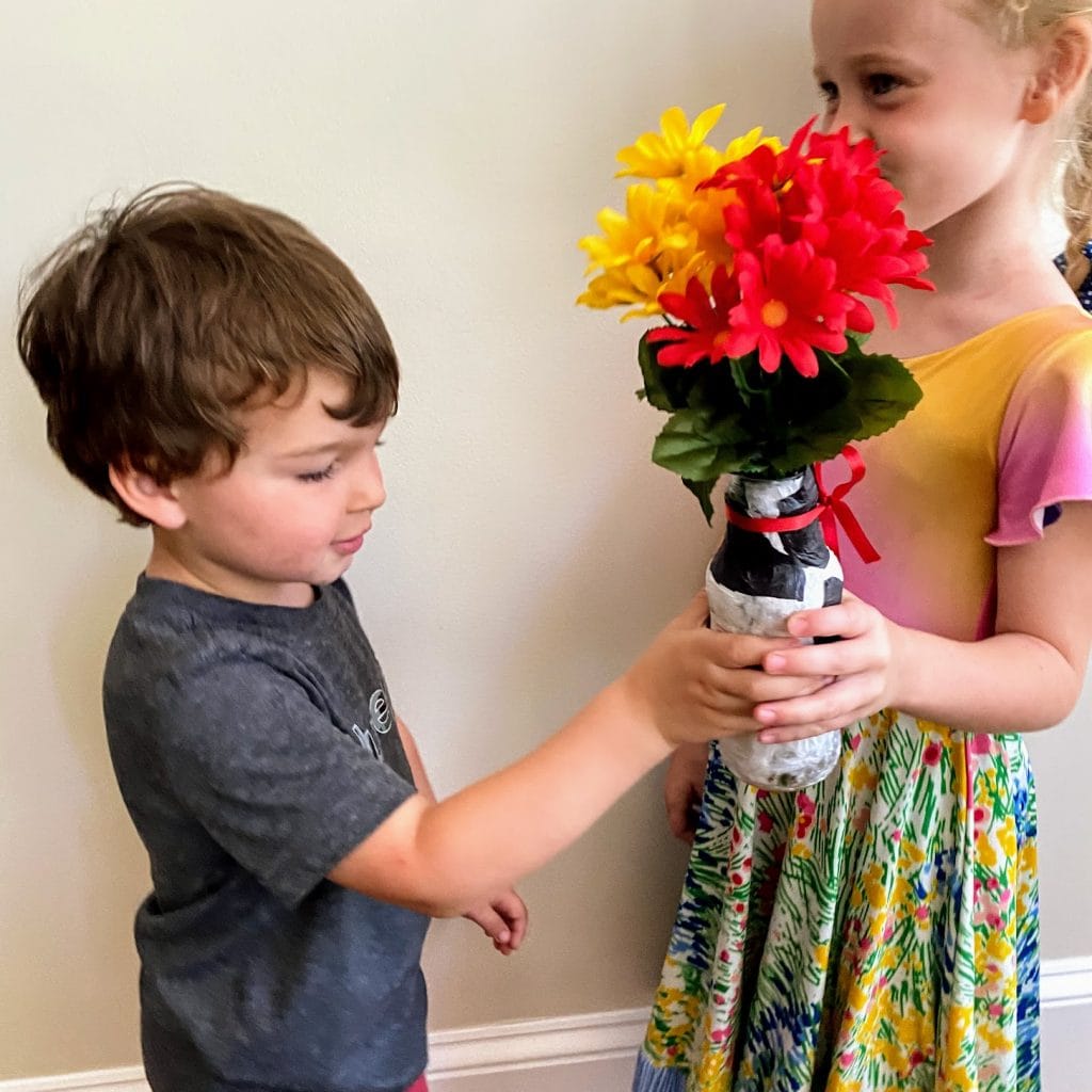 two kids playing with tissue paper vase craft