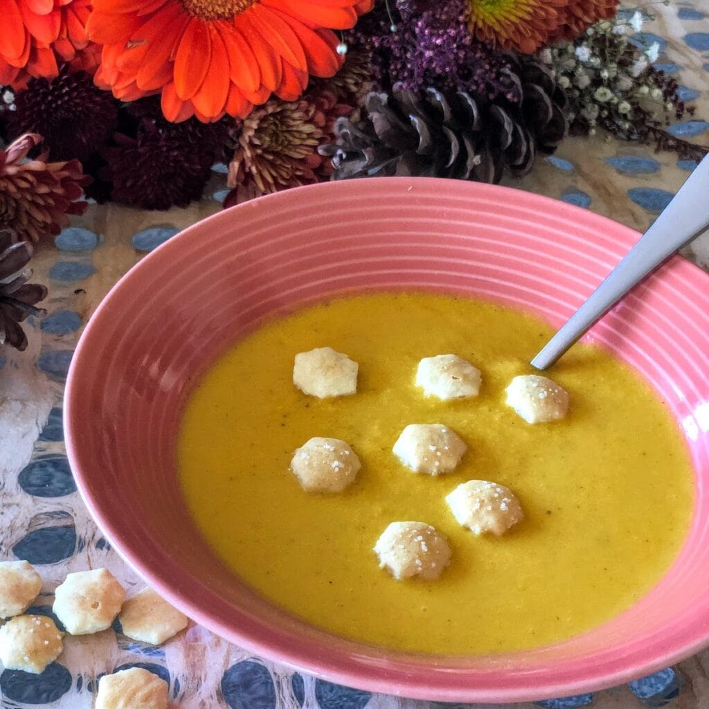 butternut squash soup in bowl topped with small crackers