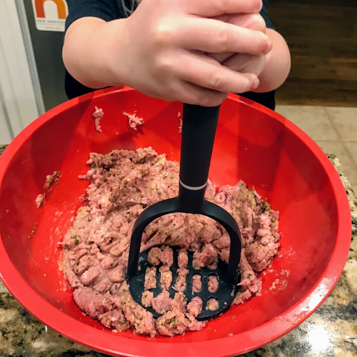 child mixing turkey burger ingredients