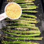 adding cheese to asparagus