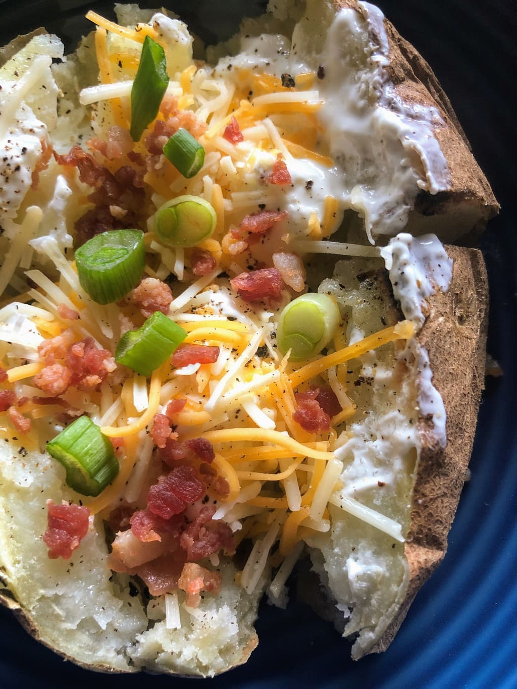 baked potato with scallions, cheese, bacon and sour cream