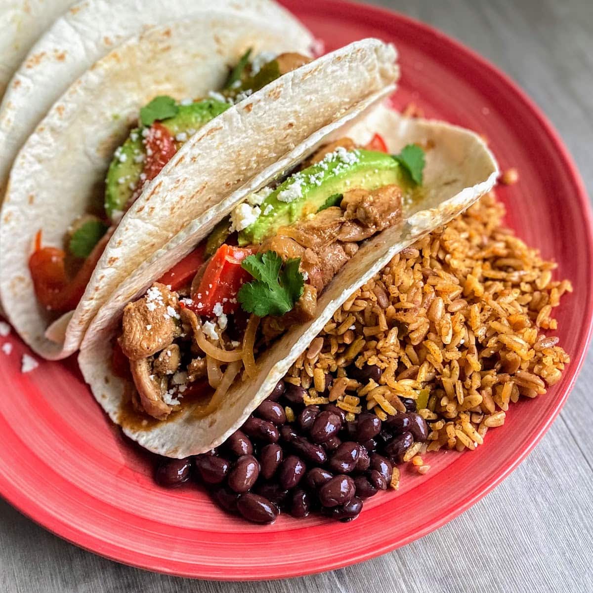 soft tacos with fajita chicken, rice and beans