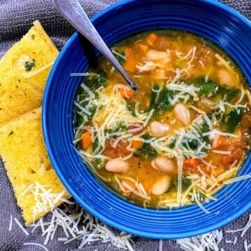 blue bowl with white bean soup sprinkled with parmesan cheese
