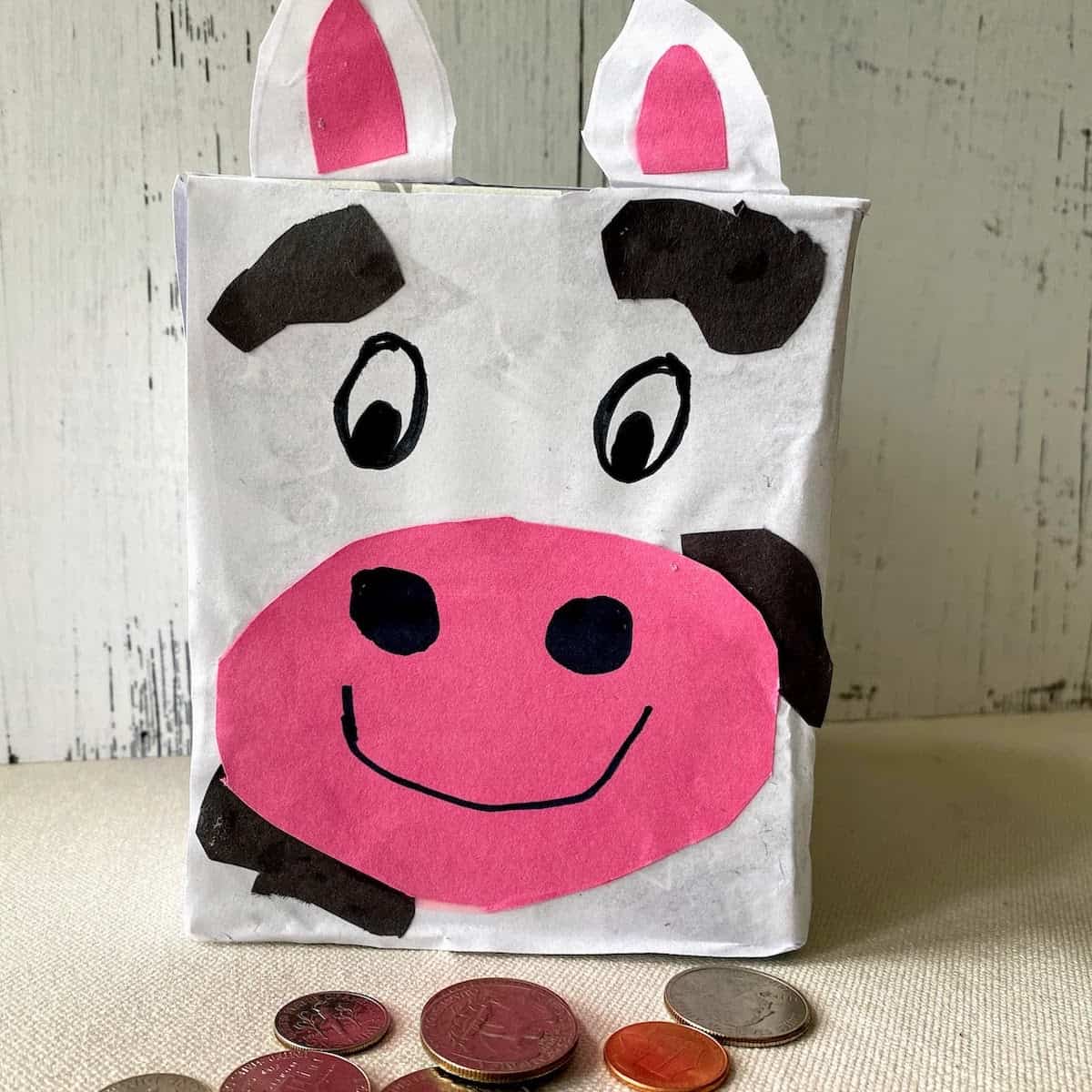 homemade cow piggy bank with coins