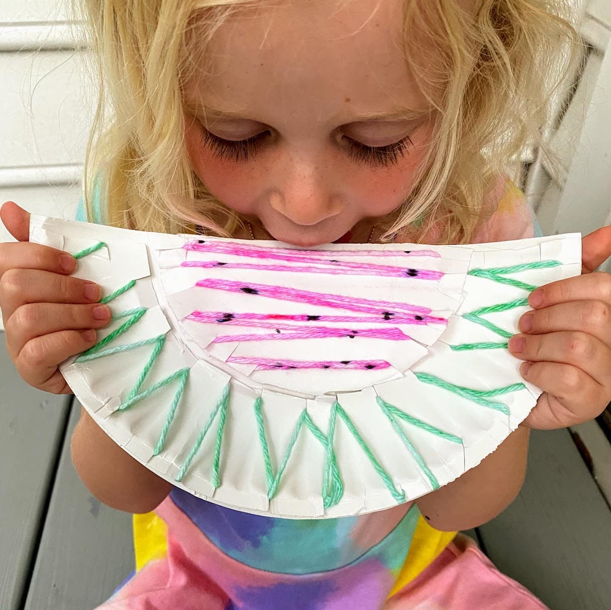 child pretending to eat watermelon