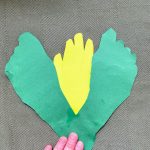 gluing green cutout footprints to yellow cutout handprint