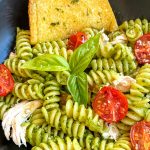 black square plate with chicken pesto pasta and roasted tomatoes