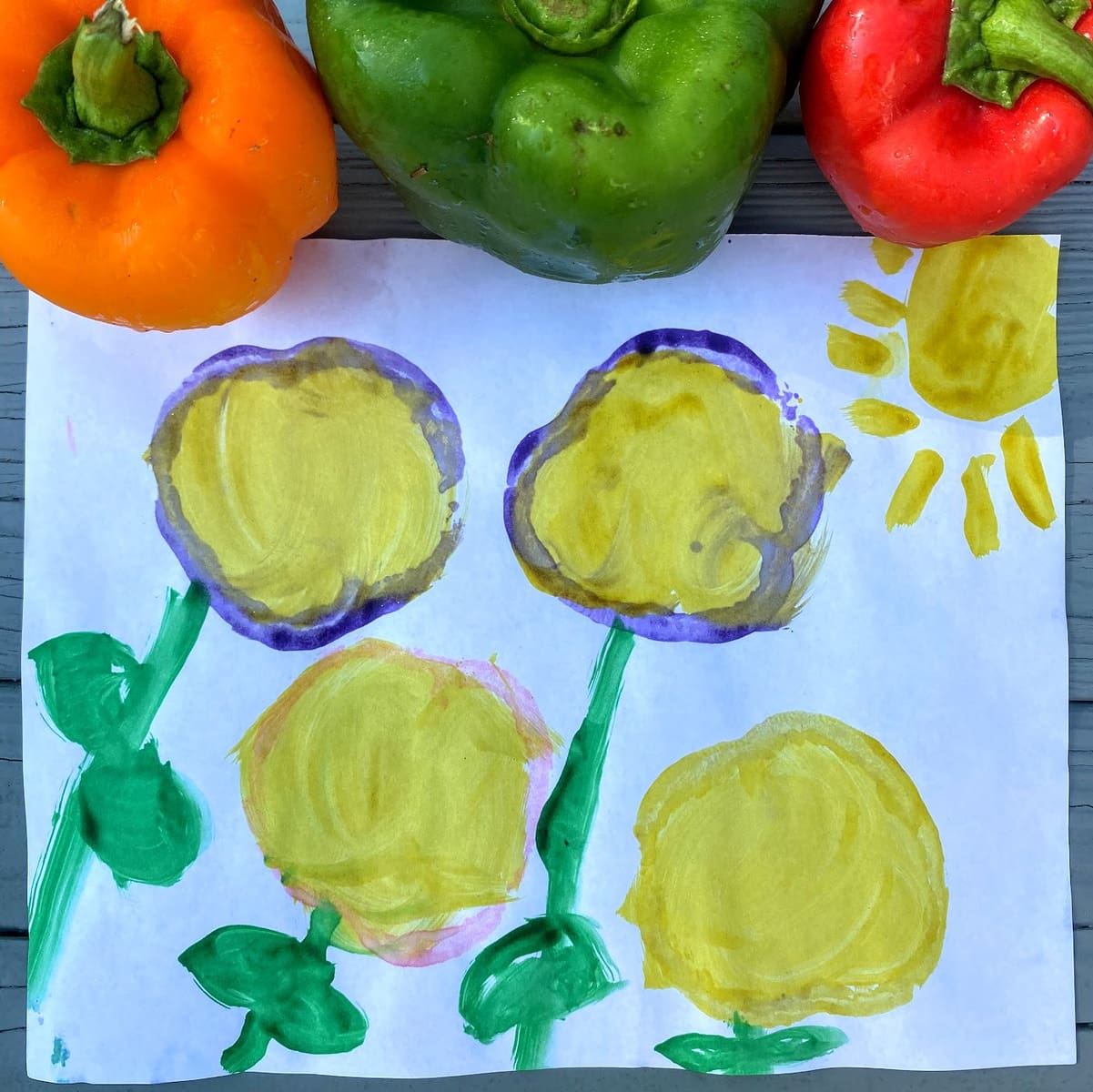 Four colorful flowers made from bell pepper stamps