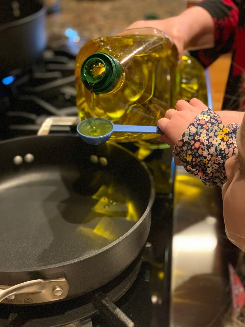 Child pouring oil into pan