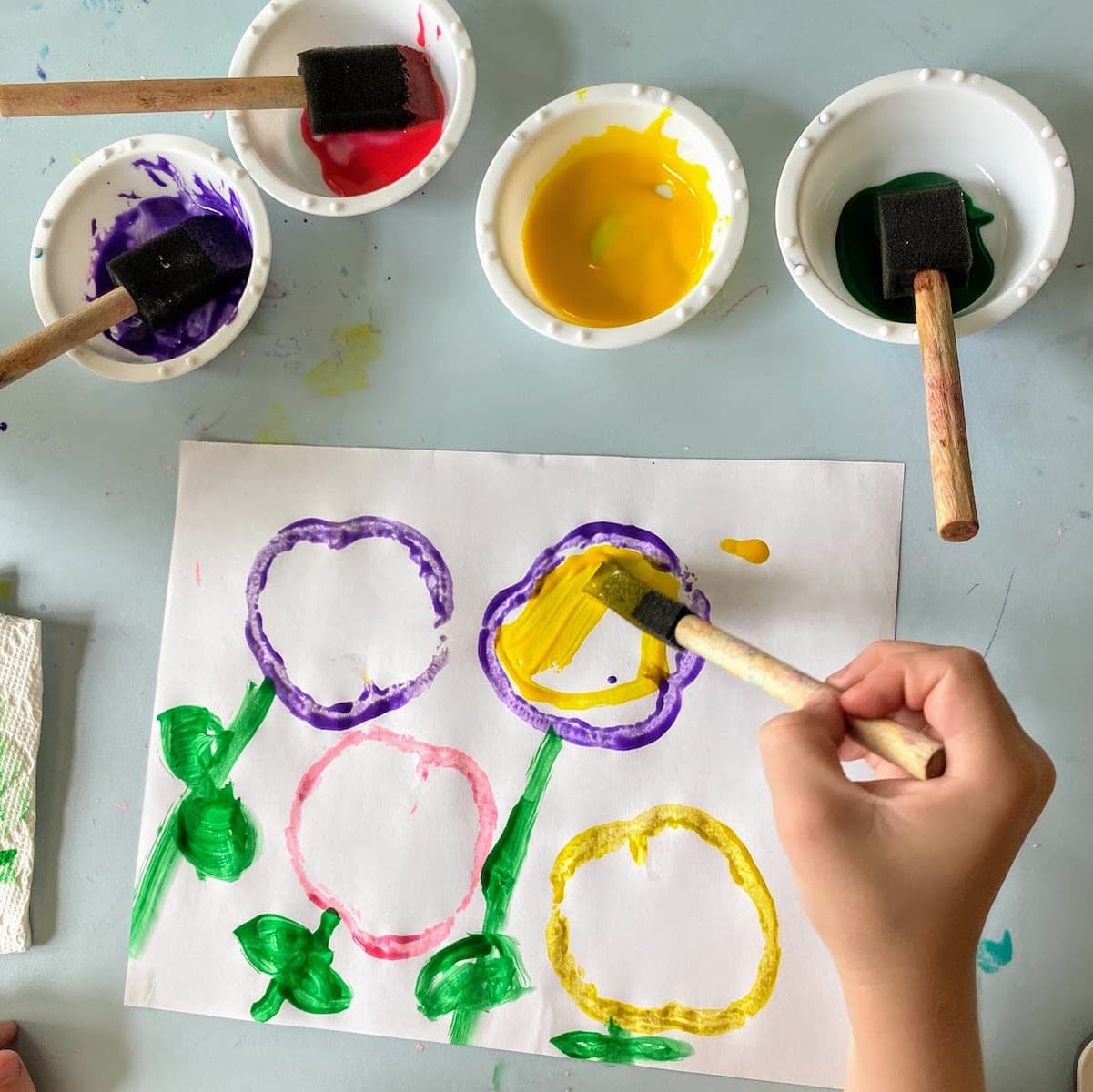 child coloring yellow flour made from bell pepper stamps