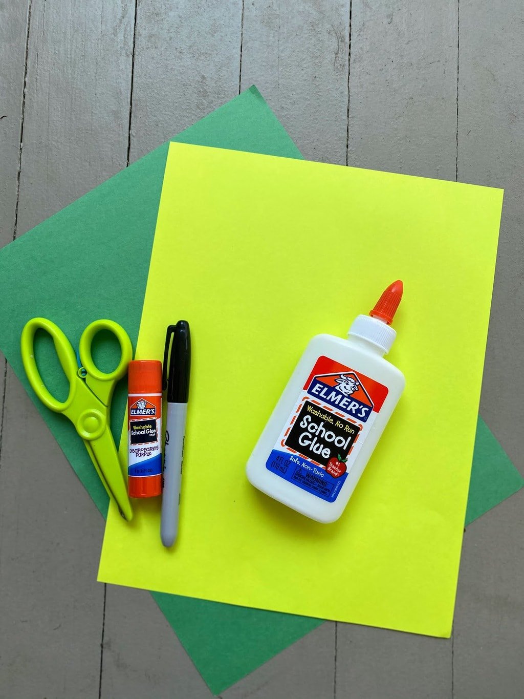 scissors, glue, black marker and yellow and green paper for olive oil bottle craft