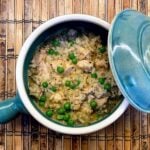 chicken, rice and peas in small blue crockpot with lid on side