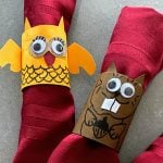 two DIY critter napkin rings on red napkins