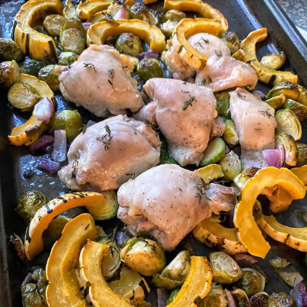 baked chicken and squash on baking sheet
