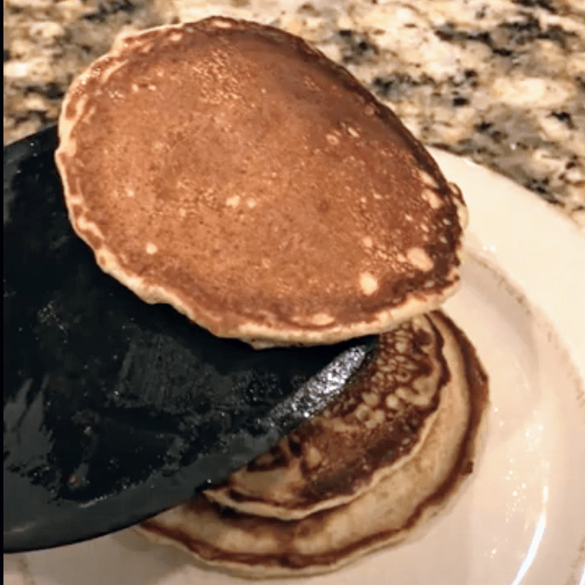 placing pancakes onto plate with spatula