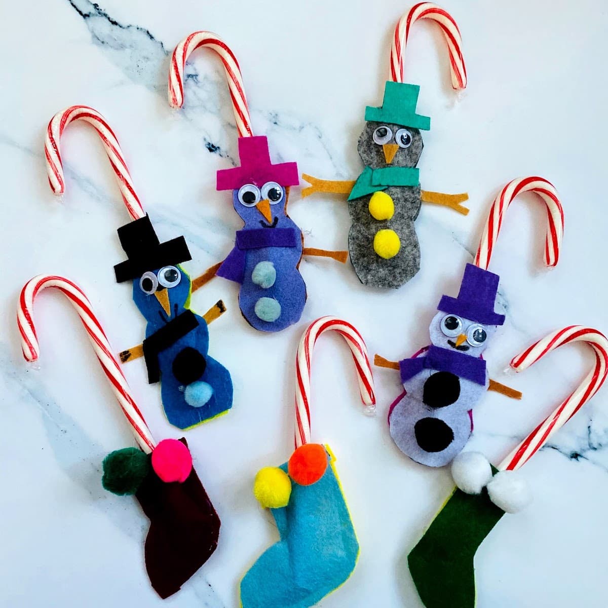 assortment of felt snowmen and stalkings holding candy canes 
