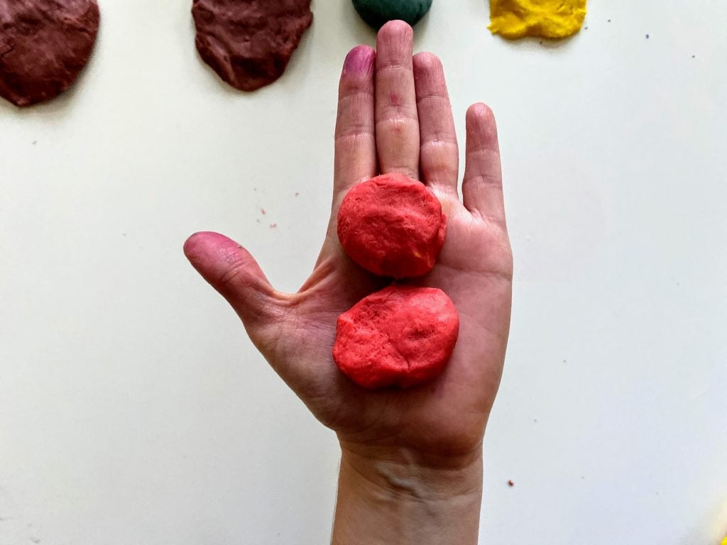 ball of pink play dough in hand