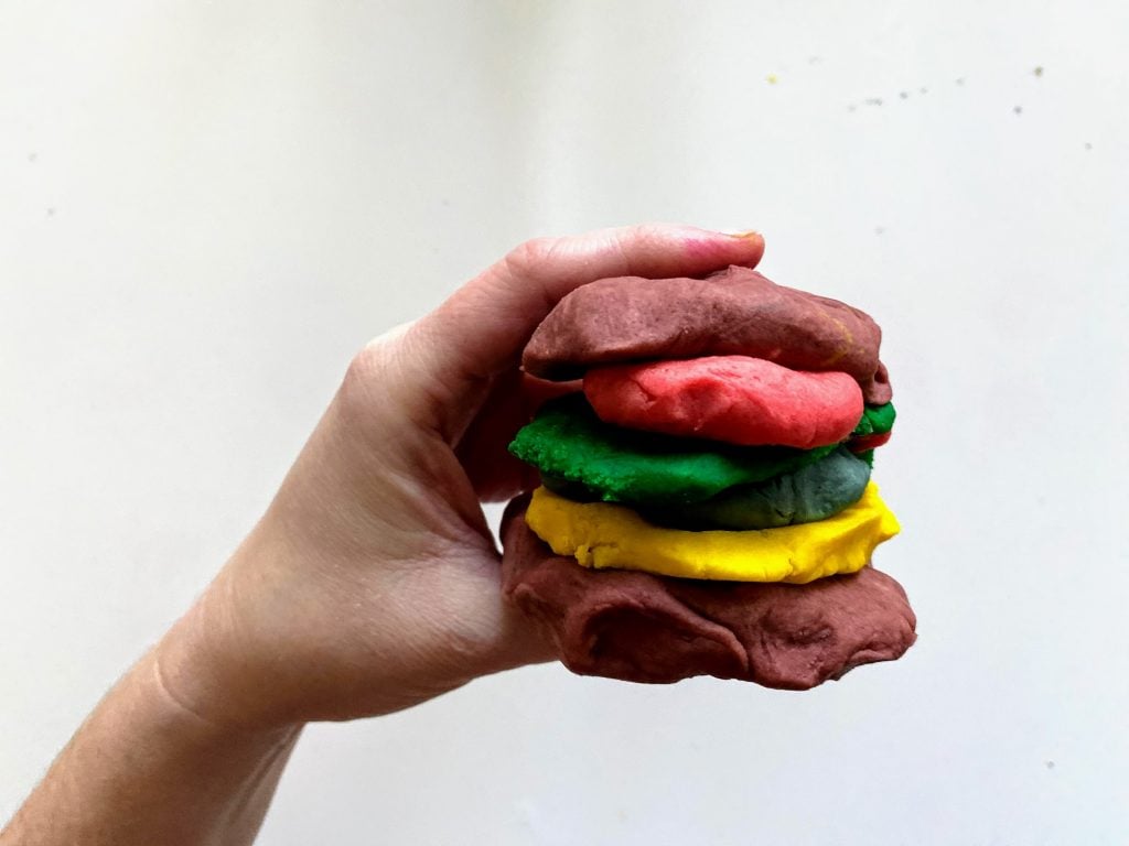hand holding play dough cheeseburger